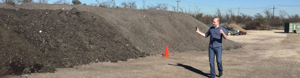Galen demonstrates how to hold the phone, while videoing a stockpile.