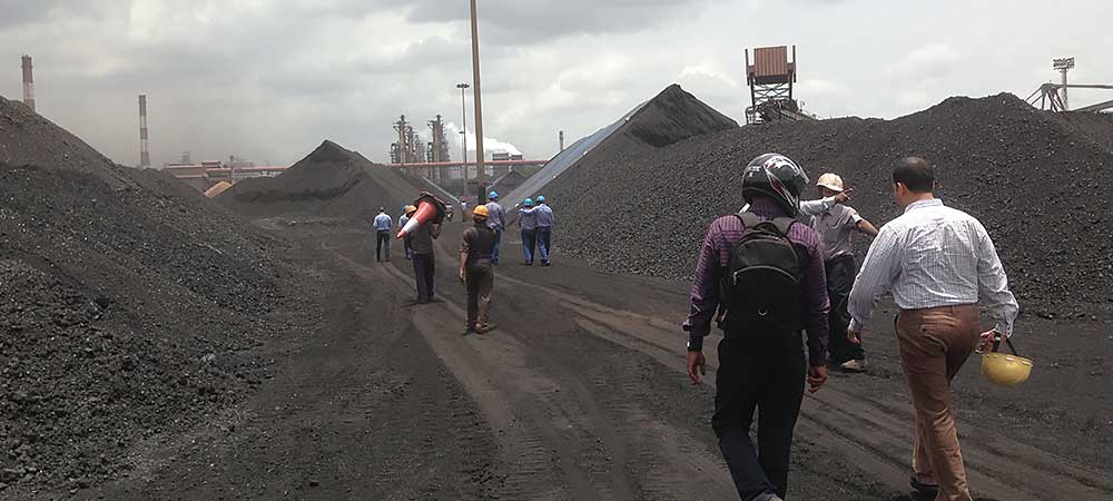 Walking onsite in India, preparing to measure coal stockpiles.