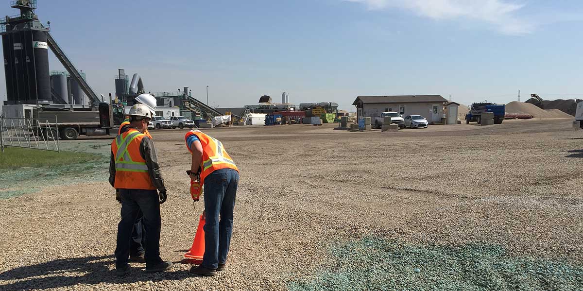 A customer is getting ready to measure stockpile inventory, with measuring tape, 2 construction cones and an iPhone.